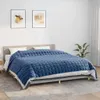 A blue quilted blanket is laid out on a bed with white pillows. Produktbild-Vorschau