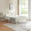 A bedroom scene with a white metal bed frame. Voir les images du produit