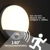 A close-up of a white LED wall light with a motion sensor, showing its features and specifications. Produktbild-Vorschau