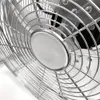 A close-up view of the metal grill and central part of a fan. Voir les images du produit