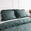A close-up view of a bed with green bedding, including two pillows and a duvet cover. Produktbild-Vorschau