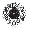A black wall clock with a modern, abstract design against a white background. Produktbild-Vorschau