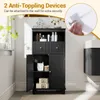 A black bathroom cabinet with doors and drawers is shown in a well-lit room, with some decorative items on top and inside. An inset image shows how to attach an anti-toppling device. Anteprima dell’immagine prodotto