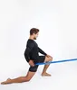 A man is performing a stretching exercise with a resistance band. Podgląd zdjęcia produktu