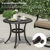 A round patio table with a cake and drinks on it, next to a chair, with a decorative fence in the background. Podgląd zdjęcia produktu