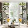 A living room scene with two S-shaped plant stands filled with flowers, placed next to a large window. Anteprima dell’immagine prodotto