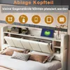 A bed with a headboard featuring storage compartments and a tablet displaying a charging icon. Produktbild-Vorschau