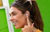 A woman is shown wearing wireless earbuds and smiling. Anteprima dell’immagine prodotto