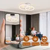 A hand holding a smartphone showing a ceiling light, with a room scene in the background. Podgląd zdjęcia produktu