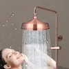 A woman is enjoying a shower with a copper shower head. Produktbild-Vorschau