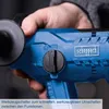 A close-up shot of a person holding a blue power tool, focusing on the control dial and brand logo. Produktbild-Vorschau