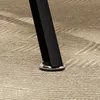 A close-up of the base of a black table leg with a silver adjustable foot resting on a textured tan carpet. Produktbild-Vorschau