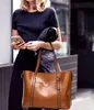 A woman holding a phone and a handbag. Produktbild-Vorschau