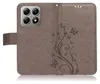 A brown flip phone case with a floral and butterfly embossed design. Produktbild-Vorschau