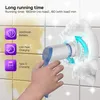 A hand holding a white and blue electric cleaning brush with blue arrows indicating rotation and foam around the brush head, set against a tiled background with yellow stains. Produktbild-Vorschau