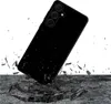 A black smartphone case is shown falling onto a surface, with debris scattering around it. Náhled obrázku produktu