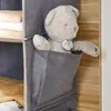 A teddy bear peeking out of a hanging closet organizer pocket. Produktbild-Vorschau