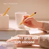 A hand holding a yellow stylus pen over a tablet, with a white mug and a pen holder in the background. Anteprima dell’immagine prodotto