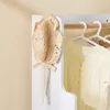 A close-up view of a child's wardrobe with a straw hat hanging on the side and a yellow dress on a hanger inside. Anteprima dell’immagine prodotto