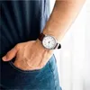 A person's arm with a watch on their wrist is shown with their hand in their jeans pocket. Produktbild-Vorschau