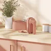 A pink hand mixer and its accessories are displayed on a wooden countertop. Voir les images du produit