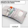 An open organizer bag for baby essentials, showing diapers, wipes, cream, and a comb. Produktbild-Vorschau