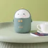 A cute duck-shaped trash can sits on a tray next to a white teacup. Produktbild-Vorschau