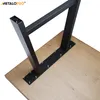 A close-up view of black metal table legs attached to a wooden tabletop. Podgląd zdjęcia produktu