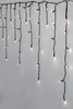 A string of LED lights hanging against a light gray wall. Produktbild-Vorschau