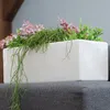 A white rectangular planter with artificial plants. Produktbild-Vorschau