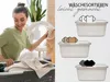A woman is doing laundry, putting clothes into a washing machine, with illustrations of laundry baskets with sorted clothes on the right side of the image. Produktbild-Vorschau