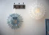Two paper star lanterns hanging on a white wall next to a coat rack. Podgląd zdjęcia produktu