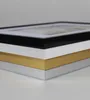 A close-up, angled view of three stacked picture frames with different colored borders: black, gold, and silver. Produktbild-Vorschau