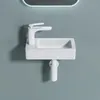 A white ceramic sink with a white faucet mounted on a light blue wall. Anteprima dell’immagine prodotto