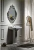 A bathroom scene featuring a pedestal sink and an ornate mirror. Anteprima dell’immagine prodotto