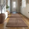A long hallway with a rug on the floor and a plant in a pot. Produktbild-Vorschau