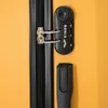 A close-up view of a yellow suitcase with a black combination lock and zipper. Produktbild-Vorschau