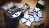 A collection of vintage photography equipment, including a film scanner, a vintage camera, and various slides and film rolls, arranged on a wooden surface. Produktbild-Vorschau