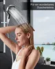 A woman is showering in a modern bathroom with a view of tropical huts on the water. Produktbild-Vorschau
