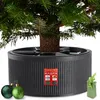 A Christmas tree stand with a Christmas tree in it, along with two Christmas ornaments and a gift box. Náhľad obrázku produktu