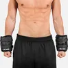A person wearing black weight cuffs on their wrists. Náhľad obrázku produktu