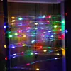 A string of colorful LED lights is draped vertically against a wooden background. Produktbild-Vorschau