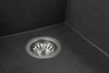 A close-up view of a sink drain in a black speckled sink. Produktbild-Vorschau