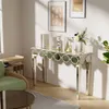 A mirrored console table with decorative elements is shown in a well-lit room, next to a green armchair and a coffee table. Produktbild-Vorschau