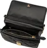 An open black quilted handbag with gold hardware. Produktbild-Vorschau