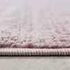 Close-up view of the edge of a pink and white rug. Voir les images du produit