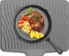 A cooked meal is presented on a black plate, which is placed on a gray silicone drying mat. The meal consists of a steak, spaghetti, asparagus, cherry tomatoes, and orange slices. Produktbild-Vorschau