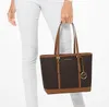 A person is holding a Michael Kors tote bag. Produktbild-Vorschau