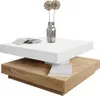 A modern coffee table with a white top and a wooden base, decorated with a vase of dried flowers and some books. Produktbild-Vorschau