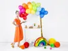 A woman in an orange dress is standing next to a party cart decorated with balloons and party favors. Náhľad obrázku produktu